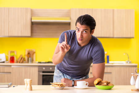 Young man in unhealthy food conceptの写真素材