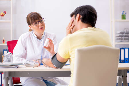 Young doctor checking patients blood pressureの写真素材