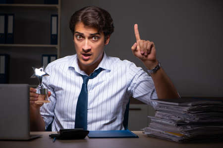 Young financial manager working late at night in officeの写真素材
