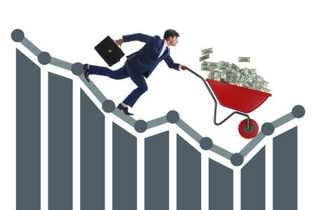 Businessman pushing money wheelbarrow down the chartの写真素材