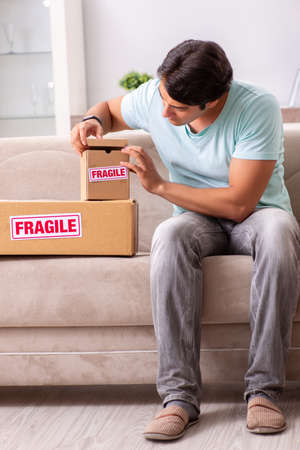 Man opening fragile parcel ordered from internetの写真素材