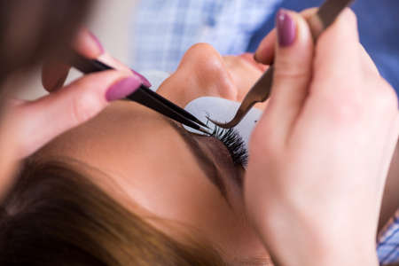 Young woman getting eyelash extension