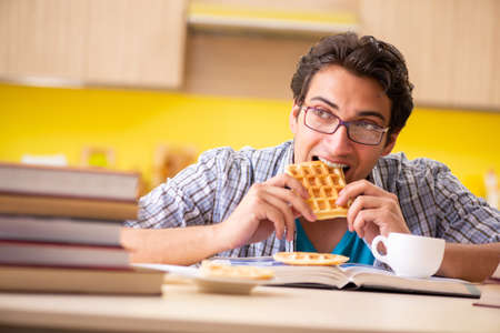 Student preparing for exam sitting at the kitchenの写真素材