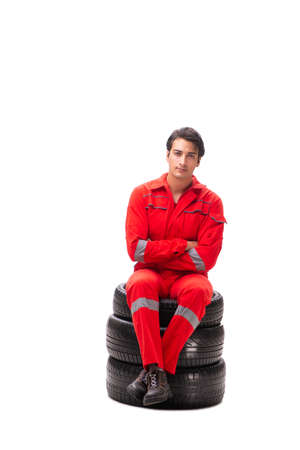 Young garage worker with tyre isolated on whiteの写真素材