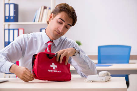 Man with first aid kit in the officeの写真素材