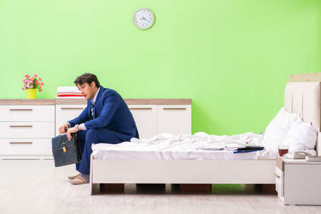 Businessman working overtime in hotel roomの写真素材