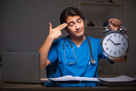Young handsome doctor working night shift in hospitalの写真素材