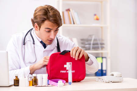 Young doctor with first aid kit in hospitalの写真素材
