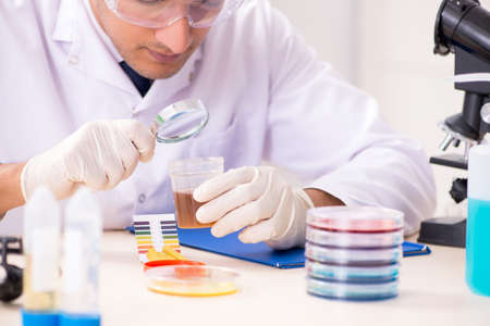 Chemist in the lab checking with ph strips