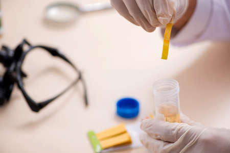 Chemist in the lab checking with ph stripsの写真素材