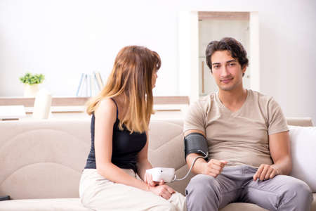 Wife checking husbands blood pressureの写真素材