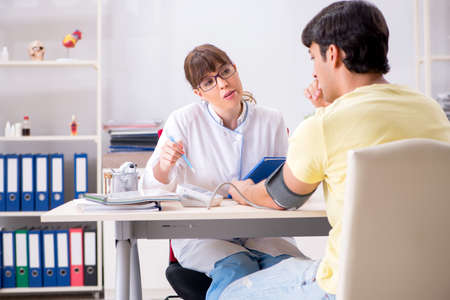 Young doctor checking patients blood pressureの写真素材