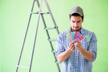Young man contractor choosing color from rainbowの写真素材