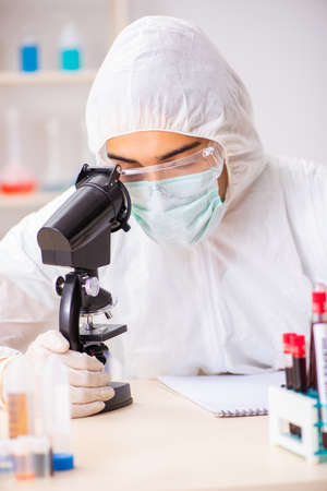 Young handsome lab assistant testing blood samples in hospitalの写真素材