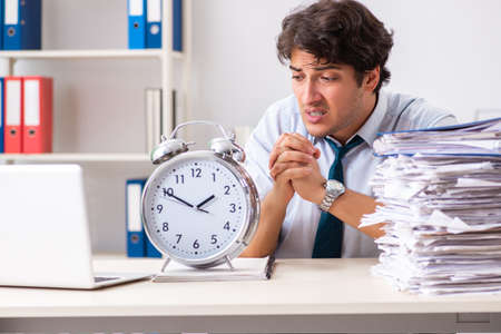 Overloaded busy employee with too much work and paperworkの写真素材