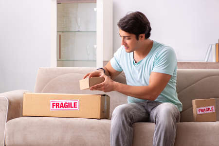 Man opening fragile parcel ordered from internetの写真素材