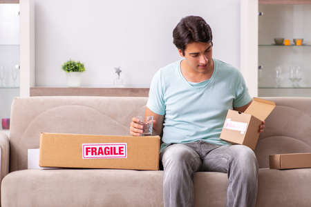 Man opening fragile parcel ordered from internetの写真素材