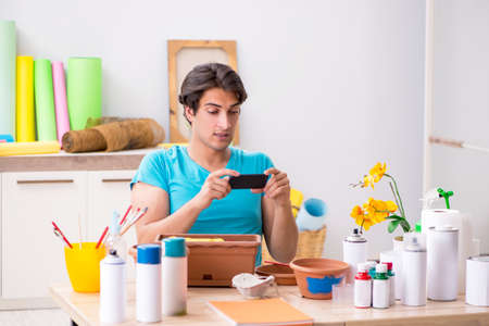 Young man decorating pottery in classの写真素材