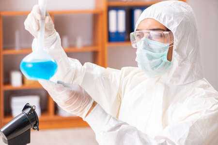 Young biochemist wearing protective suit working in the lab