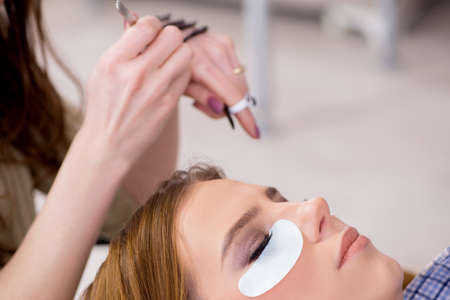 Young woman getting eyelash extension
