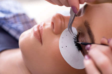 Young woman getting eyelash extension