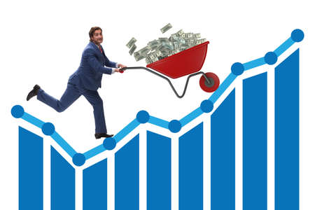 Businessman pushing wheelbarrow full of dollar moneyの写真素材