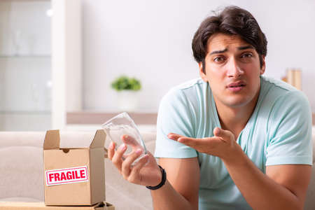 Man opening fragile parcel ordered from internetの写真素材