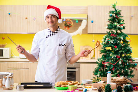 Young chef husband working in kitchen at Christmas eveの写真素材