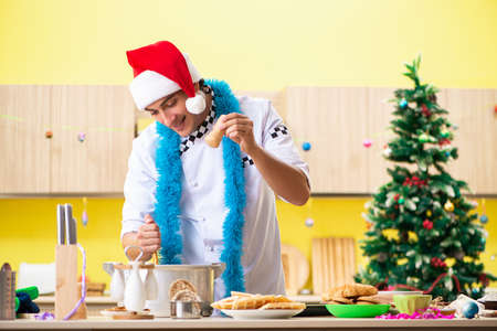 Young chef husband working in kitchen at Christmas eveの写真素材