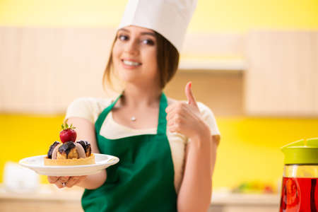 Young cook cooking cakes in the kitchenの写真素材