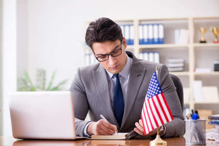 Businessman with American flag in officeの写真素材