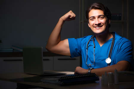 Young handsome doctor working night shift in hospitalの写真素材
