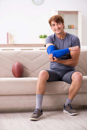 Injured man recovering at home from sports injuryの写真素材