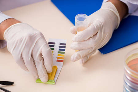 Chemist in the lab checking with ph stripsの写真素材