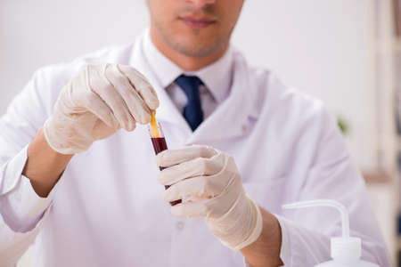 Chemist in the lab checking with ph stripsの写真素材