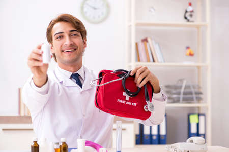 Young doctor with first aid kit in hospitalの写真素材