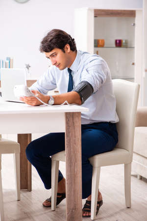 Man under stress measuring his blood pressureの写真素材