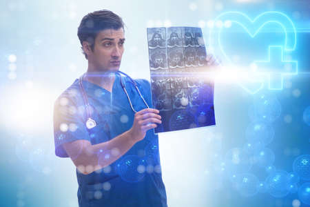 Young doctor looking at x-ray image in mhealth conceptの写真素材