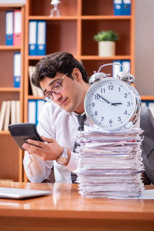 Young handsome businessman unhappy with excessive workの写真素材