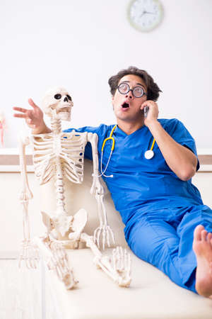 Funny doctor with skeleton in hospitalの写真素材