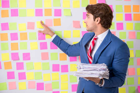 Young handsome man in conflicting priorities conceptの写真素材