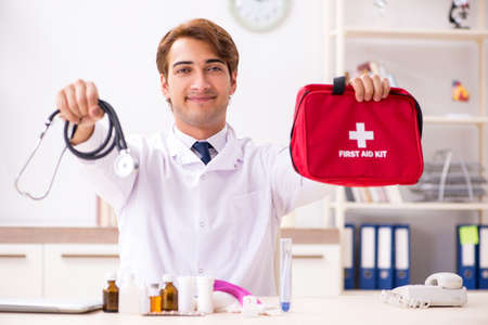 Young doctor with first aid kit in hospitalの写真素材