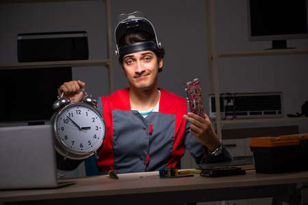 Young handsome repairman repairing computer