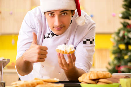 Young chef husband working in kitchen at Christmas eveの写真素材