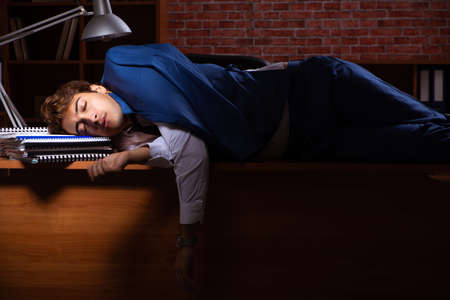 Young businessman working in the office at nightの写真素材
