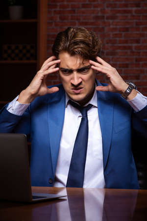 Young businessman working in the office at nightの写真素材