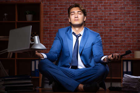 Young businessman working in the office at nightの写真素材
