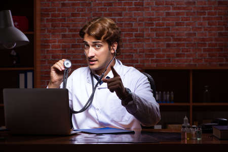 Young handsome doctor working night time at the hospitalの写真素材