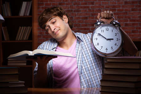 Young handsome student preparing for exams at nightの写真素材