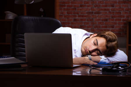 Young handsome doctor working night time at the hospitalの写真素材